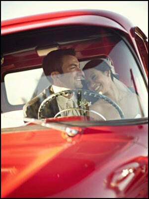 portrait of wedding couple in red truck in Salt Water Farm Vineyard in Stonington, CT